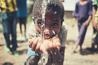 Viva con Agua boy at a water fountain